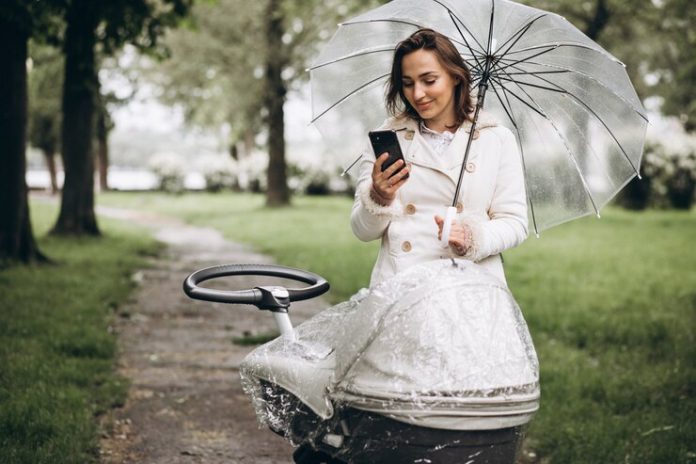 young-woman-walking-with-baby-carriage-umbrella-raint-weather_1303-22968